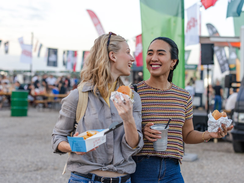 two people enjoying food at a festival